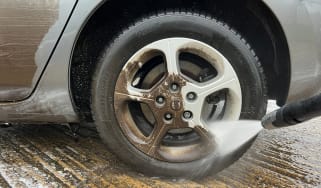 Alloy wheel being cleaned with pressure washer